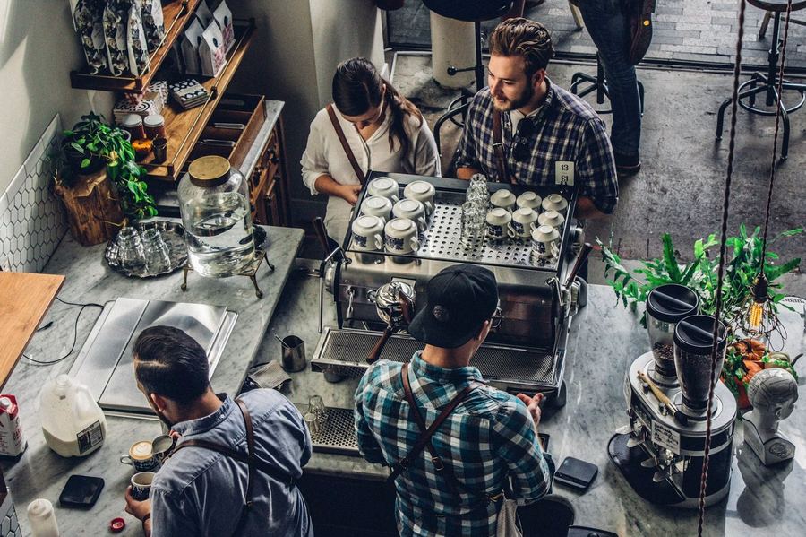 Local small business coffee shop with team working — representing the businesses Optireach helps grow online